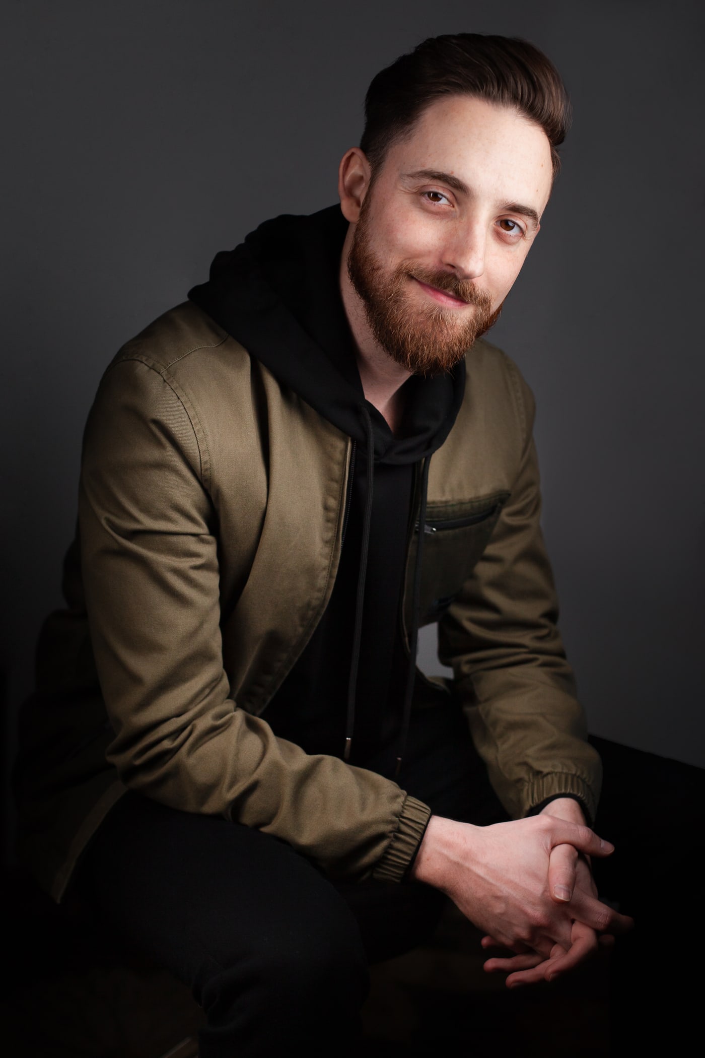 Drew Feldman, APMA®, seated and smiling in an olive jacket.